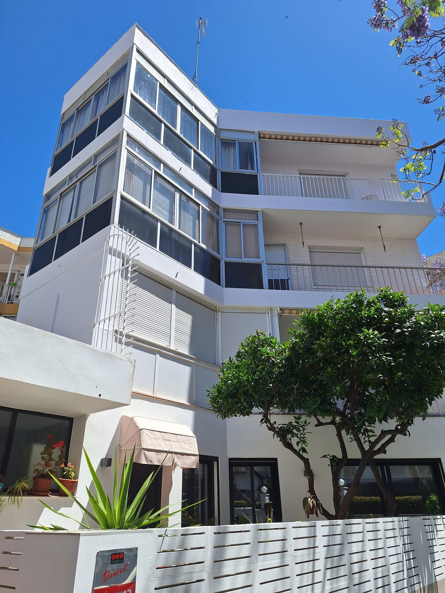 Fachada blanca renovada con balcones