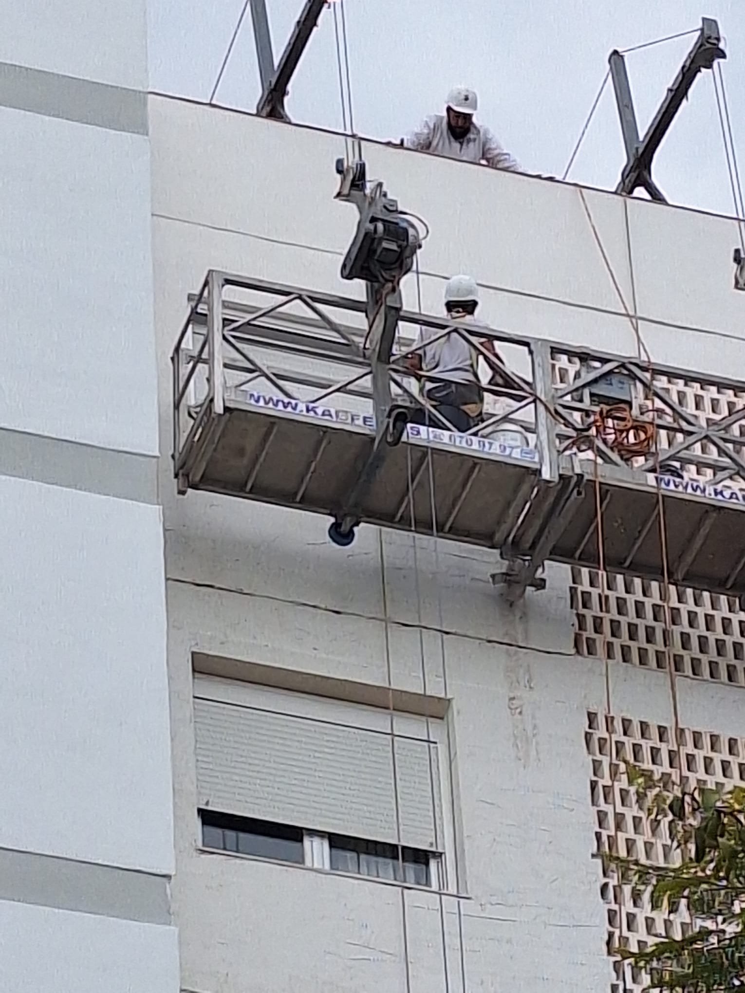 Trabajadores reparando balcón en altura